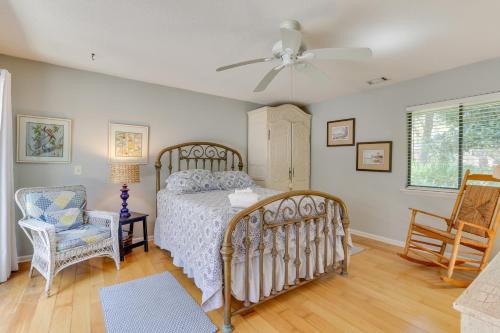 a bedroom with a bed and a chair and a ceiling fan at Bright Hilton Head Cottage with Deck about 2 Mi to Beach in Hilton Head Island