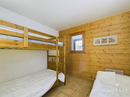 a bedroom with two bunk beds and a window at Charmant 3 pièces au centre station avec balcon, parking et WiFi gratuit - FR-1-398-579 in Montvalezan