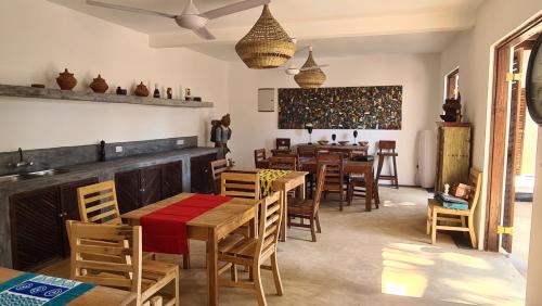 um restaurante com mesas e cadeiras de madeira e uma sala de jantar em Kholle Villa em Jambiani