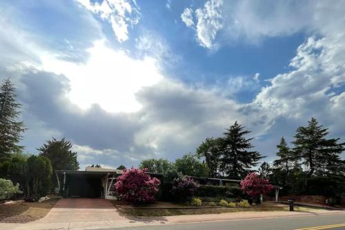 a house with pink flowers and a cloudy sky at DreamCatcher South Walk to Shop Dine Hike in Sedona