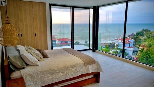um quarto com uma cama e vista para o oceano em Refugio Sova em Jama