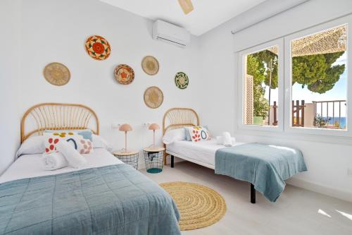 1 dormitorio con 2 camas y ventana en Casa de la Playa. Beach House with magnificent sea, en Málaga