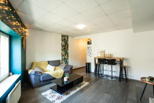 un salon avec un canapé et une table dans l'établissement Charmant logement Villefranche, à Villefranche-sur-Saône