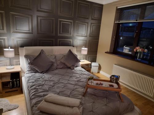 a bedroom with a bed with a table on it at Private room City skyline and mountain views close too belfast centre and airports free parking in Belfast
