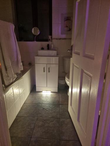 a bathroom with a white sink and a toilet at Private room City skyline and mountain views close too belfast centre and airports free parking in Belfast