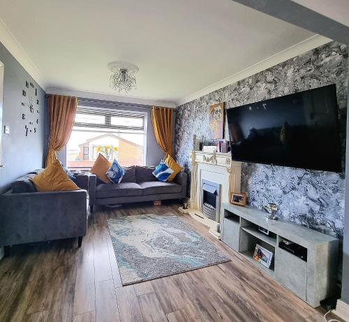 a living room with a large flat screen tv at Private room City skyline and mountain views close too belfast centre and airports free parking in Belfast