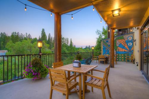 a patio with a table and chairs on a balcony at Whitefish Riverfront Hotel in Whitefish