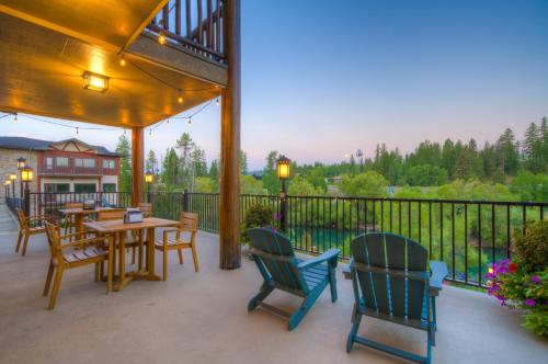 a patio with tables and chairs and a fence at Whitefish Riverfront Hotel in Whitefish