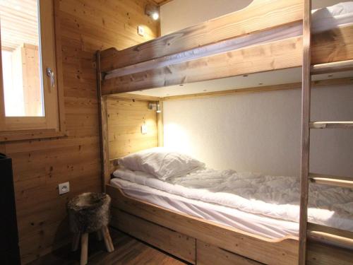 ラルプ・デュエズにあるAppartement Huez, 3 pièces, 6 personnes - FR-1-405-159の二段ベッドが備わる木造キャビンのベッド1台分です。