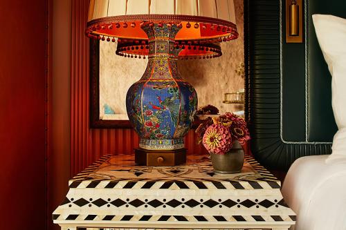 a large vase sitting on a table with a lamp at The Fifth Avenue Hotel in New York