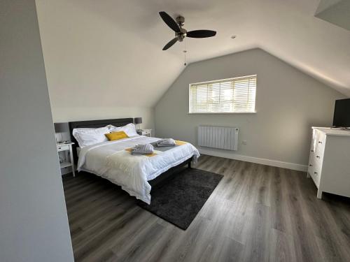 1 dormitorio con 1 cama y ventilador de techo en The Old Piggery, Cart Lodge in Newbourne en Newbourn