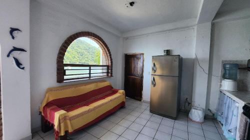 a kitchen with a refrigerator and a window in it at Villa frente al mar en Yelapa para 2 personas in Yelapa