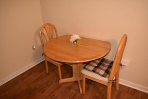 a wooden table and two chairs with flowers on it at Comforts of Home in Gautier