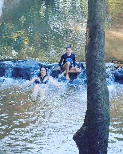 dos personas sentadas en una balsa en el agua en Camping e Balneário Rio dos Bugres, en Porcas