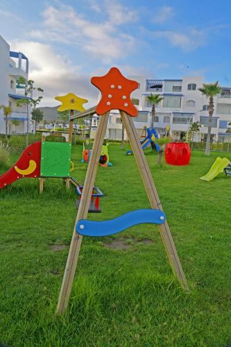 a playground with a swing set in the grass at InHome Apartment in Cabo Negro