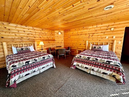 a bedroom with two beds and a desk in a cabin at The Lodge at Lolo Hot Springs in Lolo