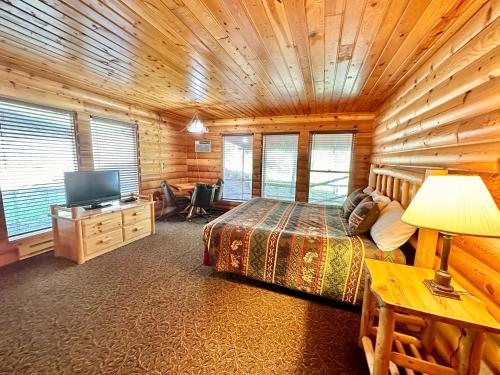 a bedroom with a bed and a television in a cabin at The Lodge at Lolo Hot Springs in Lolo