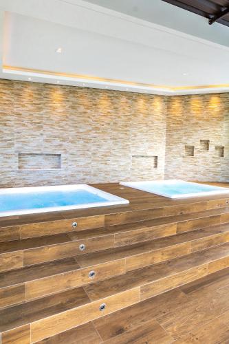 two hot tubs in a room with a brick wall at Hotel & Pousada Sonho Meu in Florianópolis