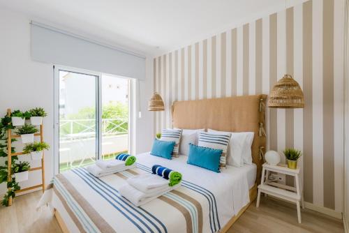 - une chambre avec un lit doté d'oreillers bleus et blancs dans l'établissement Alfamar Apartment at Praia da Falesia, à Albufeira