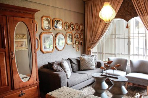 a living room with a couch and a mirror at Siesta Guesthouse & Wedding Venue - Frankfort in Frankfort