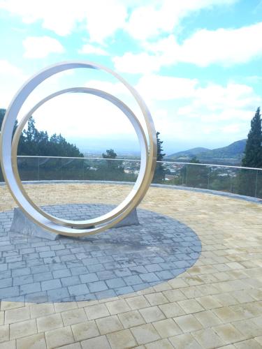 a large metal circle sculpture on a patio at Cottage and Gigo Papa's Wine Cellar in Kvareli