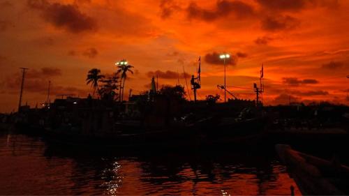 a sunset over a body of water with boats at Awaara Backpackers Hostel, Alibag in Alibag