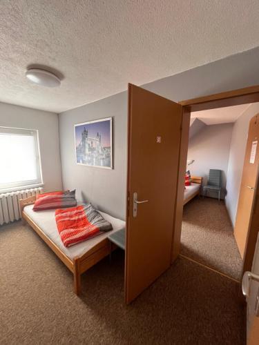 a bedroom with a bed with a door open at Pension 5 Ferienhof Hanstorf in Satow