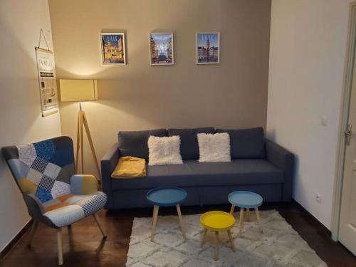a living room with a blue couch and a table at Appartement moderne en ville in Armentières