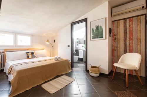 a bedroom with a bed and a chair and a bathroom at MiCo Apartment in Fiera Milano City in Milan