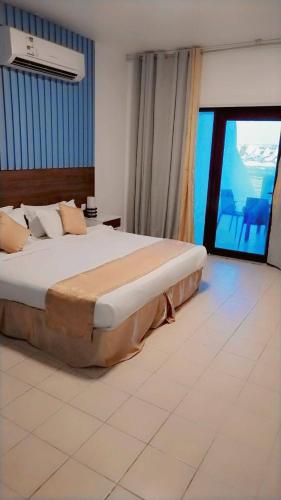 a bedroom with a large bed and a large window at Miami Paradise only family للعوايل فقط in Durat  Alarous