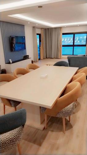 einen Konferenzraum mit einem weißen Tisch und Stühlen in der Unterkunft Miami Paradise only family للعوايل فقط in Durrat Al-Arus