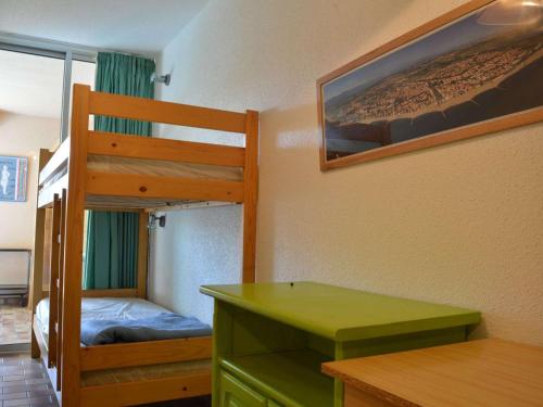 - une chambre avec des lits superposés et un bureau vert dans l'établissement Appartement T2 Cabine 6 pers proche plage, parking, BBQ - FR-1-225D-4, à Saint Cyprien Plage