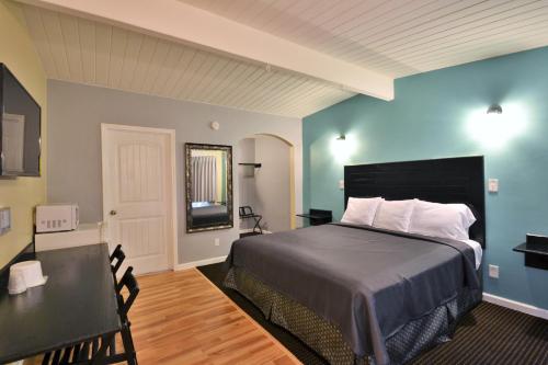 a bedroom with a bed and a table and a desk at Lodge at 32nd in San Diego