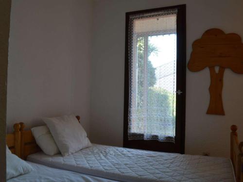 a bedroom with a bed next to a window at Appartement Saint-Cyprien, 2 pièces, 4 personnes - FR-1-225D-14 in Saint-Cyprien-Plage