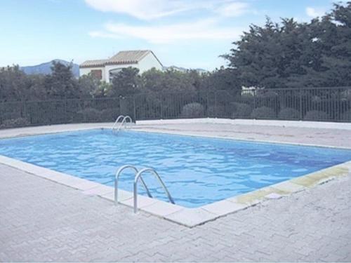 une grande piscine avec de l'eau bleue dans une cour dans l'établissement Appartement T2 avec Piscine, Proche Plage, Terrasse et Parking Privé à Saint-Cyprien - FR-1-225D-14, à Saint Cyprien Plage