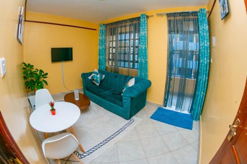 a living room with a green couch and a table at cla bnb in Kisumu