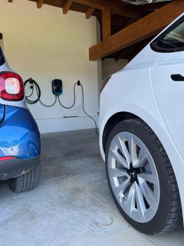 a white car parked in a garage with a car charger at Araucaria House in Barreiros