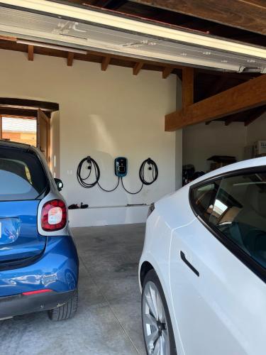 a white car parked in a garage with two bikes on the wall at Araucaria House in Barreiros