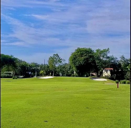 a large green field with two golf balls on it at Private Guest House in Miami