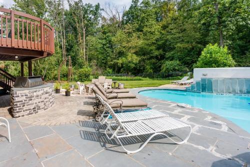 a pool with two lounge chairs and a deck at Centrally Located Family Home with Pool in Harleysville