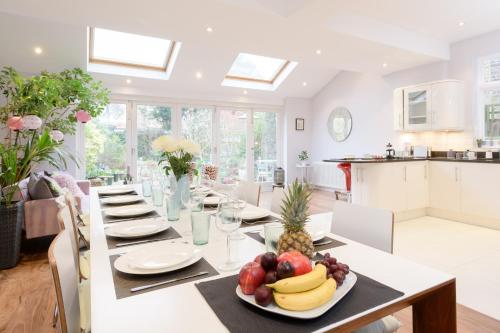 a dining room with a table with a plate of fruit on it at Luxury 6 Double Bedroom London Town house in Ealing