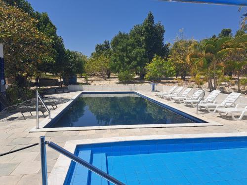 a swimming pool with lounge chairs and a swimming pool at Pousada Flats Meu Refúgio Catimbau inn in Buíque