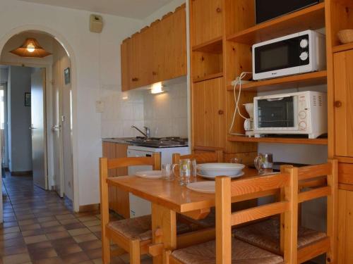 une cuisine avec une table en bois et un micro-ondes dans l'établissement Appt charmant 2P avec terrasse, proche plage, parking, BBQ - Saint-Cyprien Plage - FR-1-225D-34, à Saint Cyprien Plage