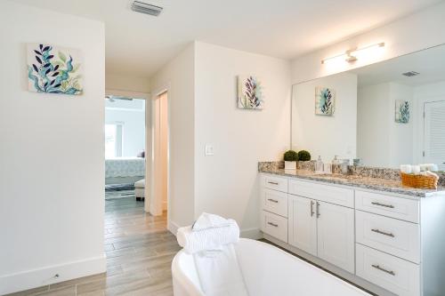 a white bathroom with a sink and a mirror at Comfy Lehigh Acres Getaway with Yard and Fireplace in Lehigh Acres