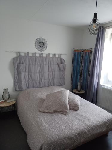 1 dormitorio con 1 cama grande y cabecero gris en Chez Anita en Plérin