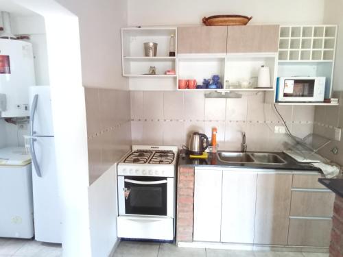 a small kitchen with a stove and a sink at Monoambiente las lilas in Puerto Madryn