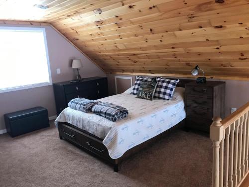 a bedroom with a bed and a wooden ceiling at Hidden Lakefront Retreat in Sherburne