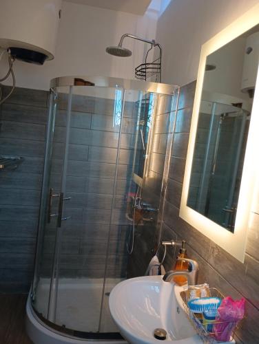 a bathroom with a glass shower and a sink at Himma's Apartments in Adonkia