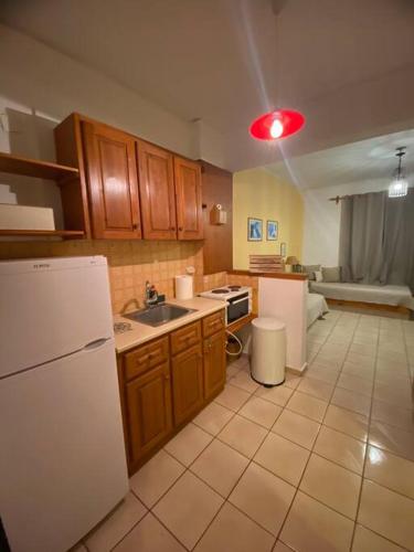 - une cuisine avec des appareils électroménagers blancs et une lumière rouge dans l'établissement 4 Beds Flat with Shared Pool, à Stalida