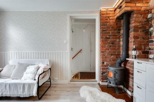 een woonkamer met een bank en een bakstenen muur bij Cosy home & terrace in a 1910-wooden house in Turku